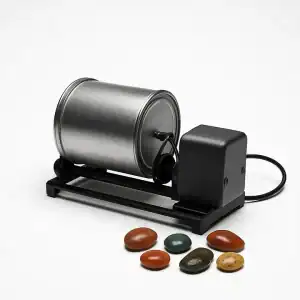 A rock tumbler with several smooth, polished rocks in front of it.