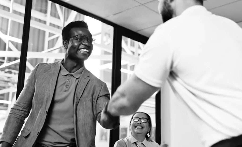 Businessman smiling and shaking hands with colleague after successful meeting